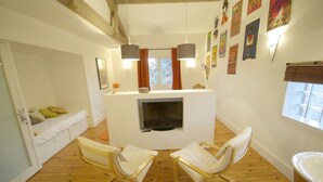 A cozy living room with a fireplace, wooden flooring, and a white sofa. - L'Oustalet D'Anicette (Valence)