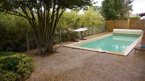 A rectangular swimming pool with a wooden deck and a hammock. - L'Oustalet D'Anicette (Valence)
