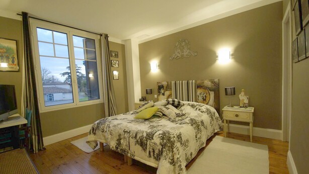 A bedroom with a bed, a nightstand, a lamp, a picture frame, and a window with curtains. - L'Oustalet D'Anicette (Valence)