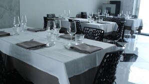 A dining area with tables set for a meal, chairs, and wine glasses. - Hotel Royal (Porto Cesareo)