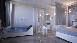 A modern bedroom with a large bed, a glass shower enclosure, and a marble floor. - Hotel Royal (Porto Cesareo)