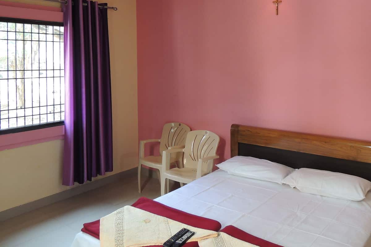 Ein Schlafzimmer mit einem Bett, einem Deckenventilator, einem Fenster mit violetten Vorhängen und einem Sessel.