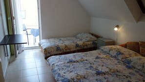 A bedroom with two beds, a desk, and a chair. - Klassz Apartmanház (Balatonfured)
