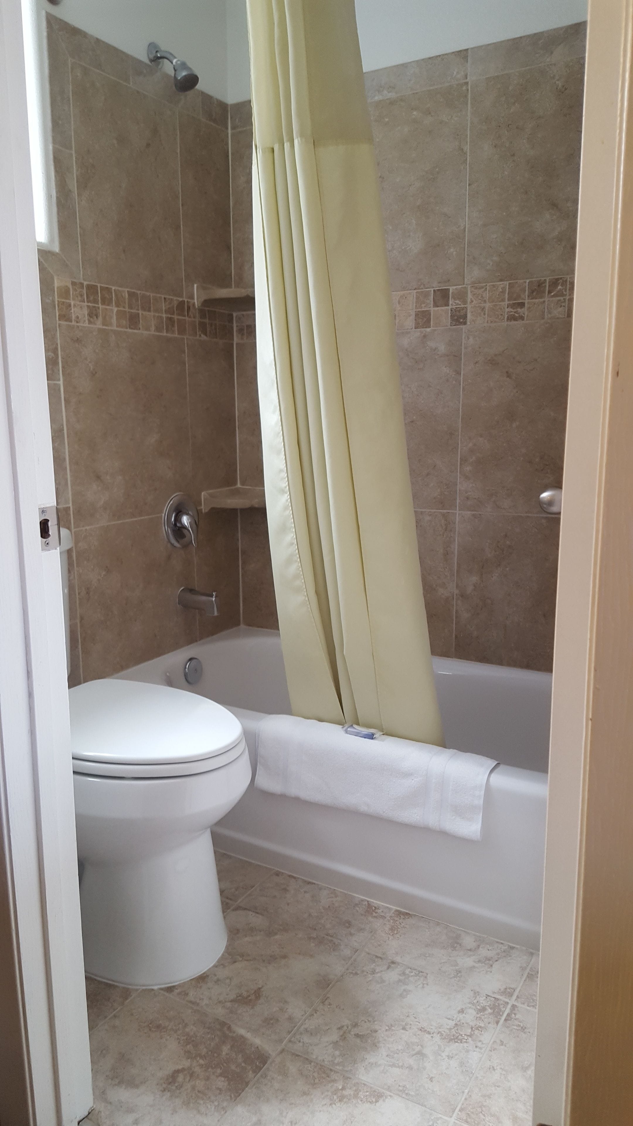 Un baño con inodoro, bañera y cortina de ducha.
