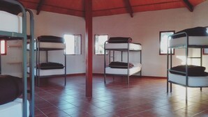 A dormitory room with bunk beds, tiled flooring, and windows allowing natural light. - Albergue Turistico Cornalvo - Hostel (Trujillanos)
