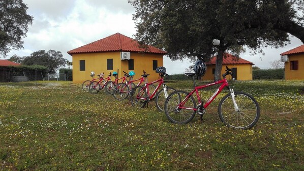 Varias bicicletas estacionadas frente a un edificio amarillo con techo rojo.