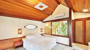 A bedroom with a large bed, wooden ceiling, and a window with a plant painting. - Pousada Sitio da Prainha (Tamandaré)