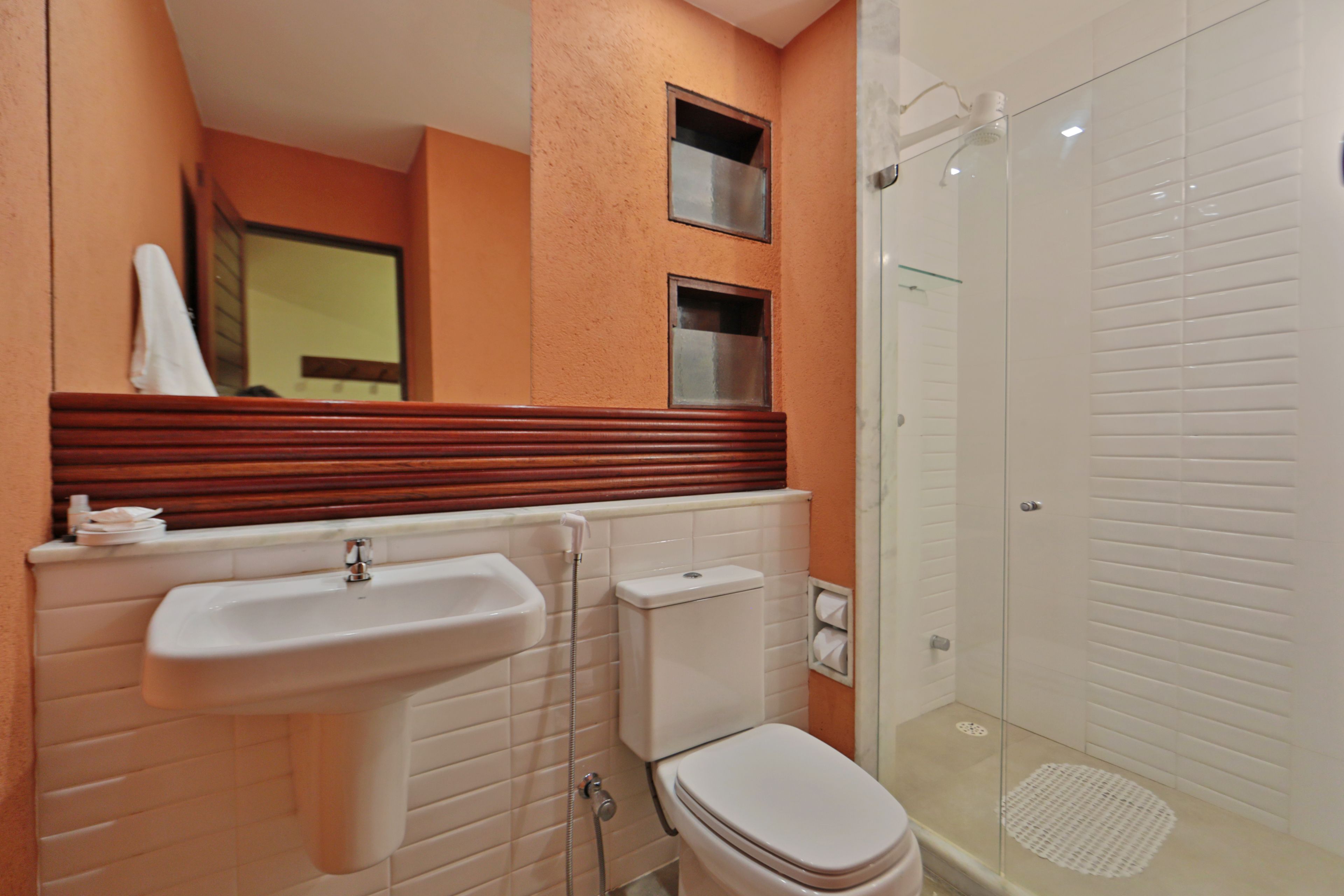A bathroom with a sink, toilet, and glass-enclosed shower.