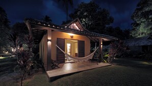 A small, single-story building with a porch, a hammock, and a thatched roof structure in the background. - Pousada Sitio da Prainha (Tamandaré)