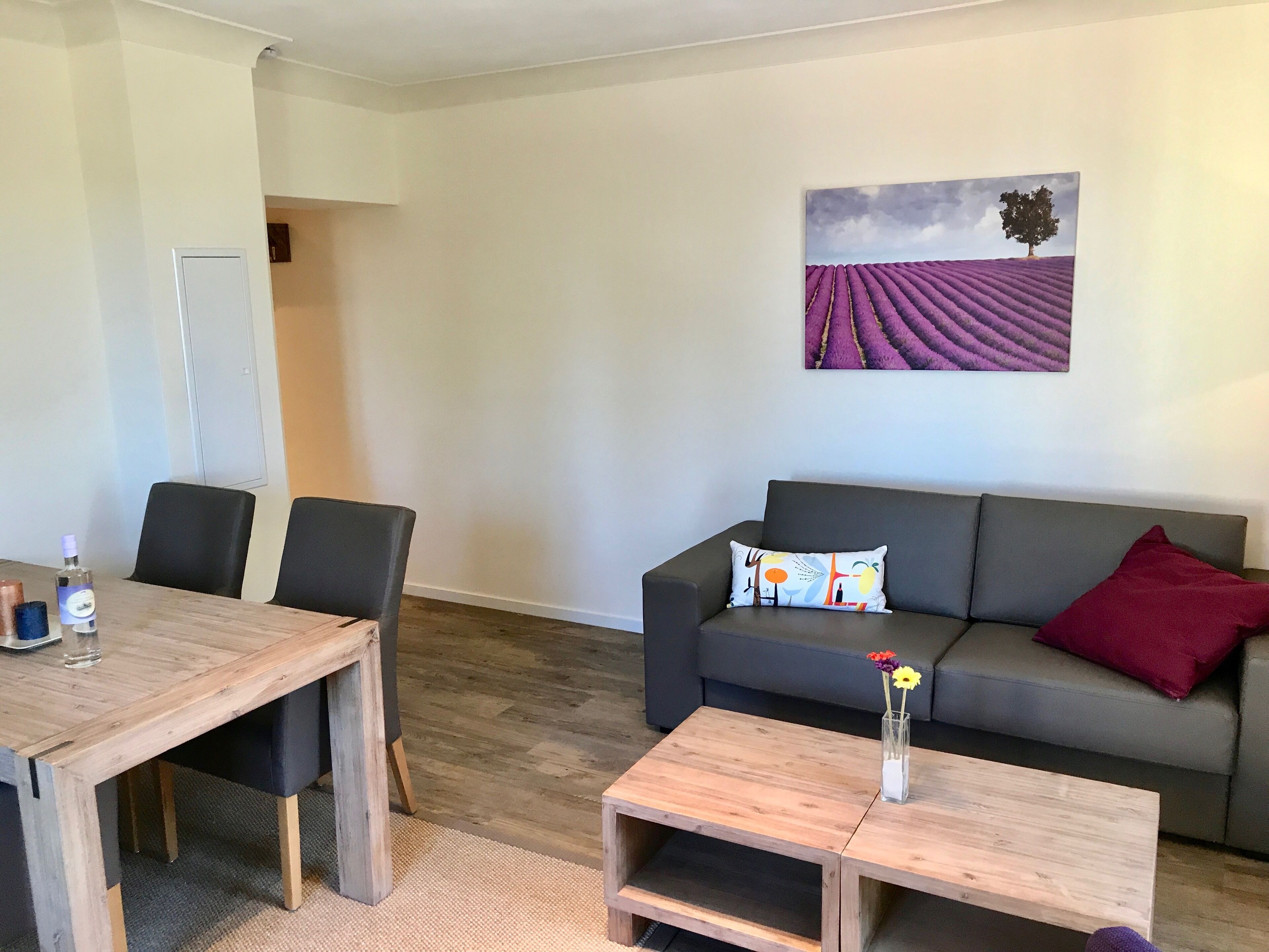 Un espace de vie comprenant un canapé, une table basse et une table à manger avec des chaises.