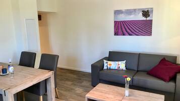 Un espace de vie comprenant un canapé, une table basse et une table à manger avec des chaises.