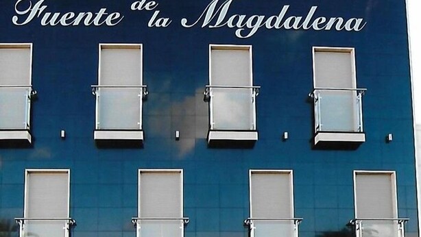 Ein Gebäude mit der Aufschrift "Hostal Fuente de la Magdalena" und mehreren Fenstern.