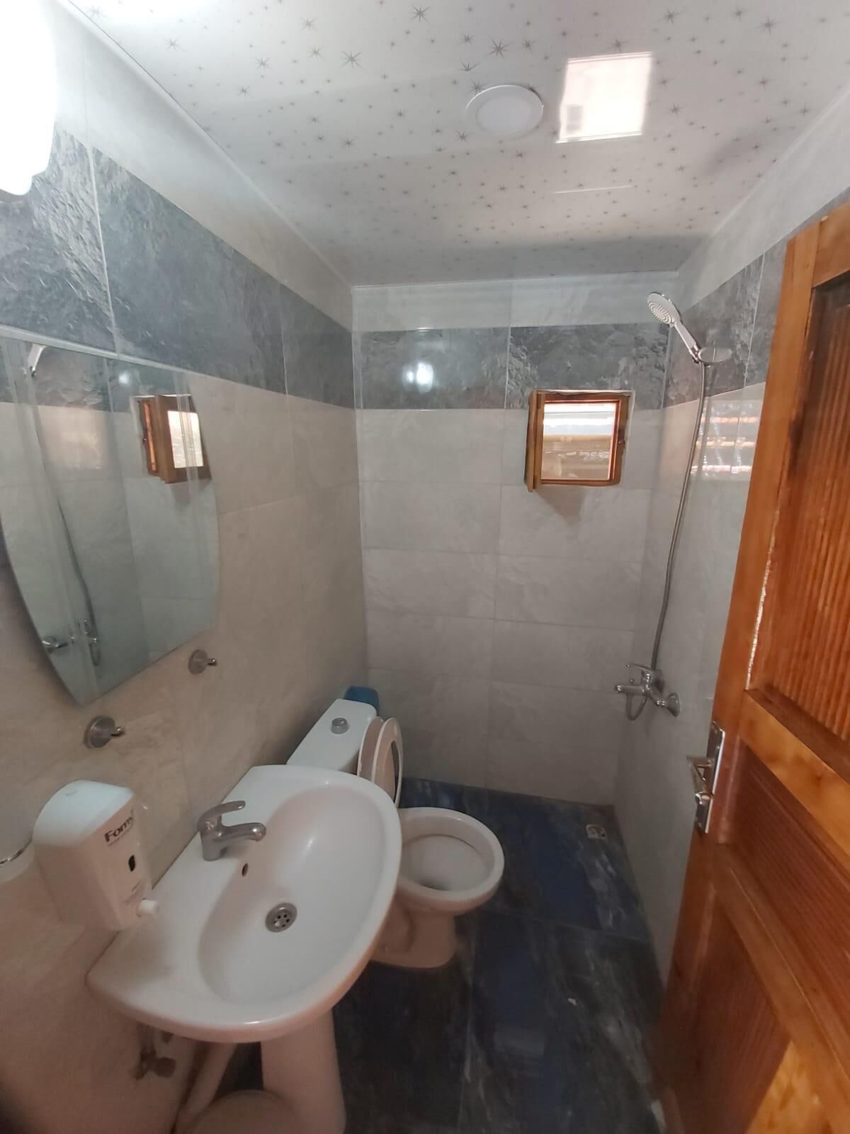 A bathroom with a sink, toilet, and shower.