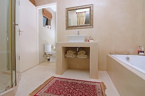 Un baño con lavamanos, espejo y bañera.