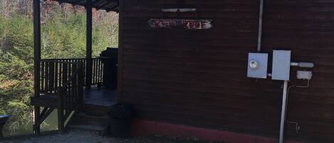 En træbygning med et skilt, der siger "RED ROOF", og et overdækket udendørsområde med en træterrasse.
