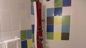 Une salle de bain avec une douche, des toilettes et un lavabo.