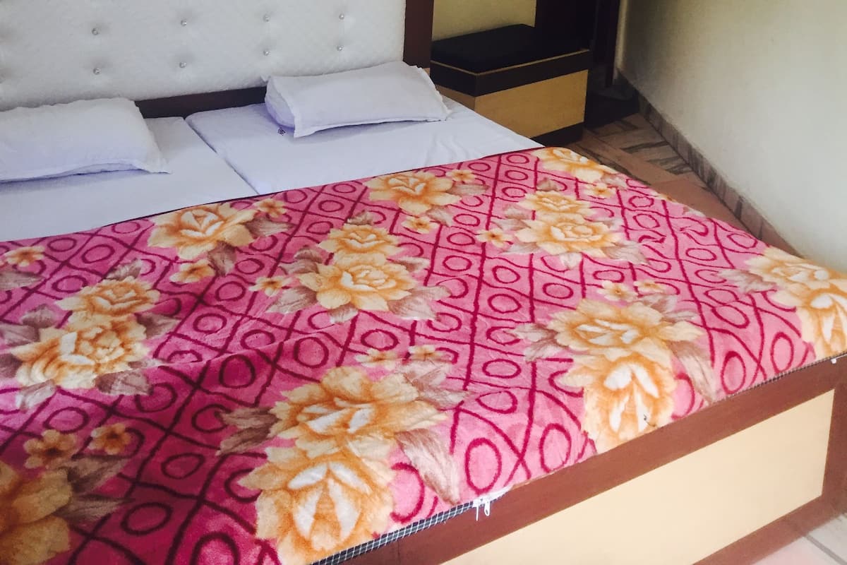 Una habitación de hotel con una cama, una mesita de noche, un espejo y una puerta.