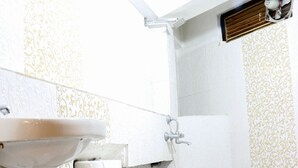 A small bathroom with a toilet, sink, and shower. - Hotel Suntejpaza (Nainital)