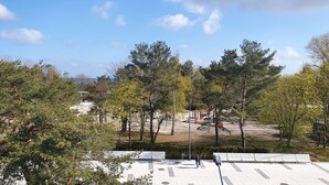 Un parque con juegos infantiles, árboles y un cielo despejado.