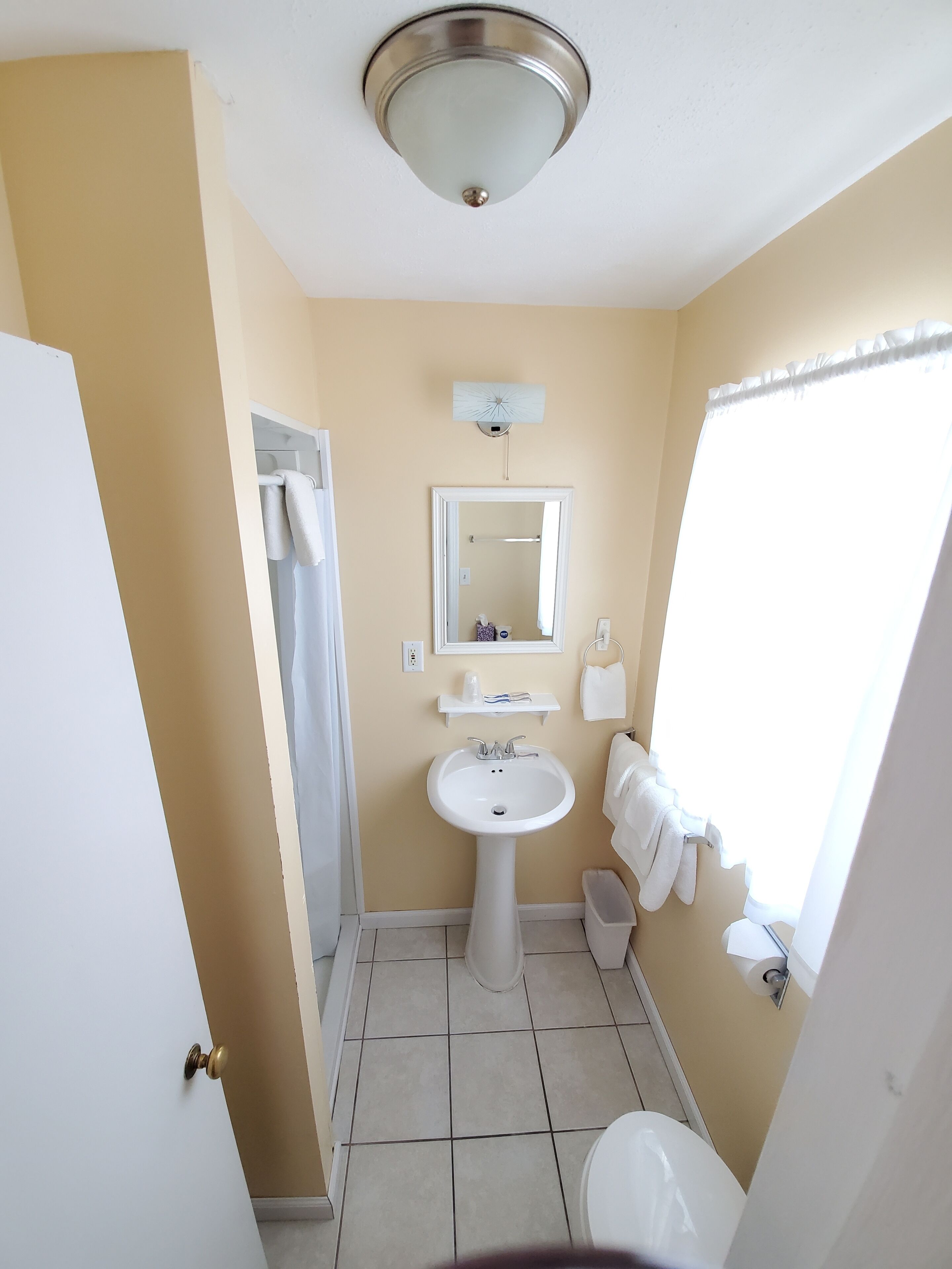 Une salle de bain avec un lavabo, un miroir et des toilettes.
