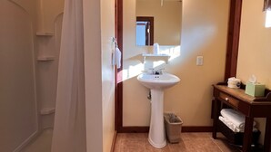 Une salle de bain avec une douche, un lavabo et des toilettes.
