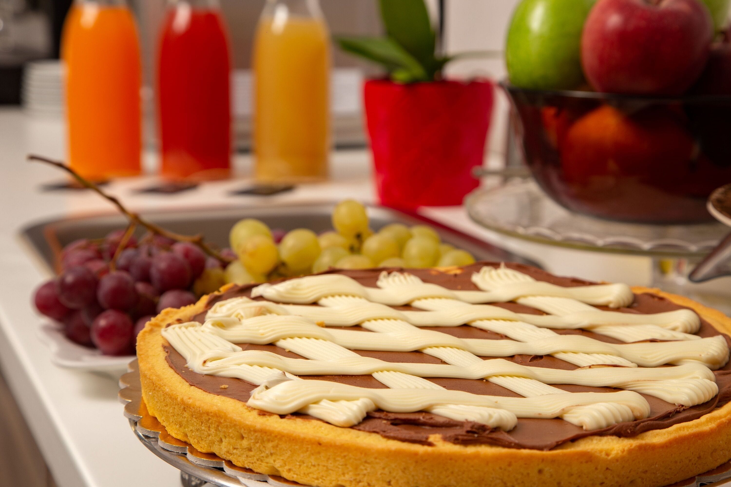 Een desserttafel met chocoladetaart en druiven.