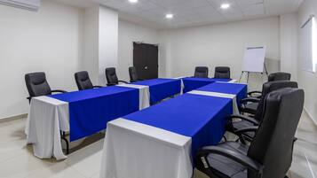 A conference room with a long table, chairs, a whiteboard, and a door.