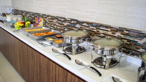 Una mesa de buffet con diferentes tipos de comida y utensilios.