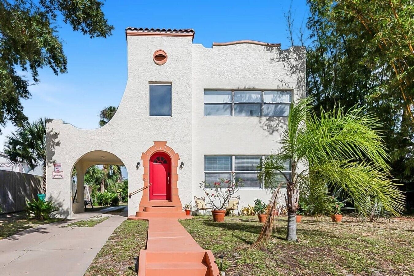 A building with a red door, a small window, and a circular window on the upper level.