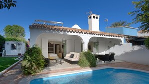 Une villa dotée d’une piscine, d’un espace salon extérieur couvert et d’un clocher.