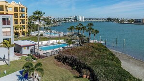 Ein Hotel am Wasser mit Pool, Palmen und Blick auf das Wasser.