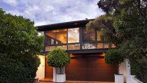 A modern two-story house with large windows, a garage, and a well-maintained garden. - BANNISTER COVE MOLLYMOOK - Art House - spa - (Mollymook Beach)