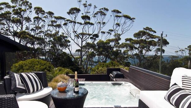 A hot tub area with seating and a bottle of champagne. - BANNISTER COVE MOLLYMOOK - Art House - spa - (Mollymook Beach)