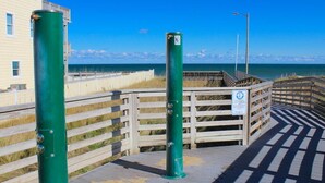 A wooden boardwalk with a metal railing, leading to a beach. - Shore Beats Work, Modern 3 Bedroom Vacation Home w/ Community Pool & Clubhouse (Kill Devil Hills)