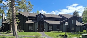 A two-story house with a dark exterior, a prominent front porch, and a well-maintained lawn. - Snowcreek Resort Vacation Rental 456 (Mammoth Lakes)