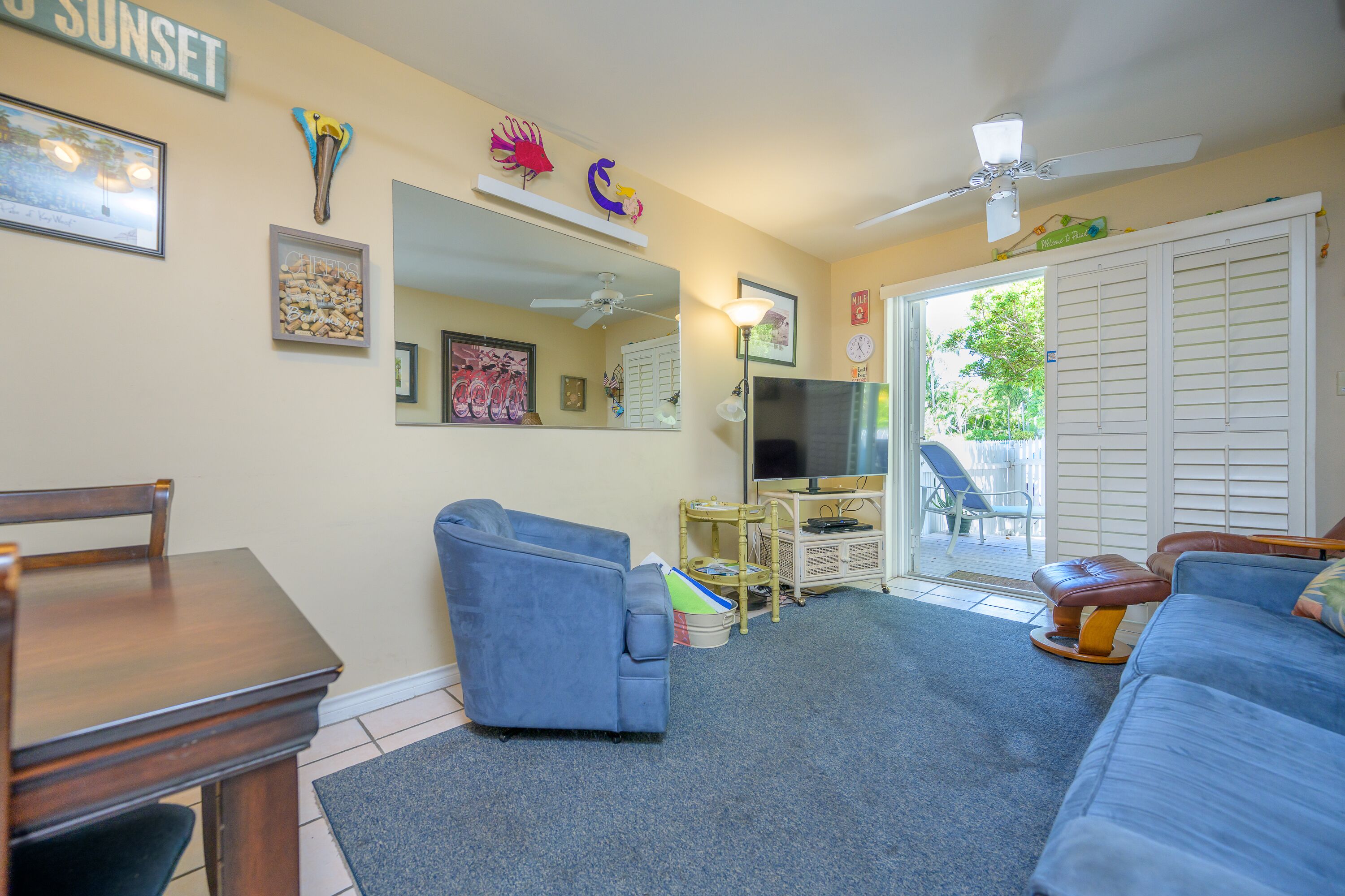A living room with a TV, blue sofa, and a dining table.