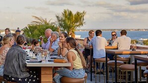 An outdoor dining area with tables and chairs, overlooking a body of water. - Boho Charm, Historic 1br -Steps to downtown (Melbourne)