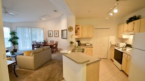 Un espacio habitable compacto con kitchenette, comedor y sofá.