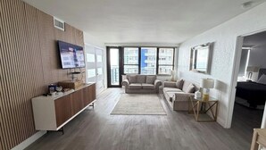 Una sala de estar moderna con pared de paneles de madera, televisor de pantalla plana, sofá, mesa de centro y alfombra.