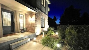 A house with a brick exterior, a front porch, and a well-lit entrance. - WOW ~ Watch the Sun Set from your Private Balcony ~ Family Gatherings  (Topeka)
