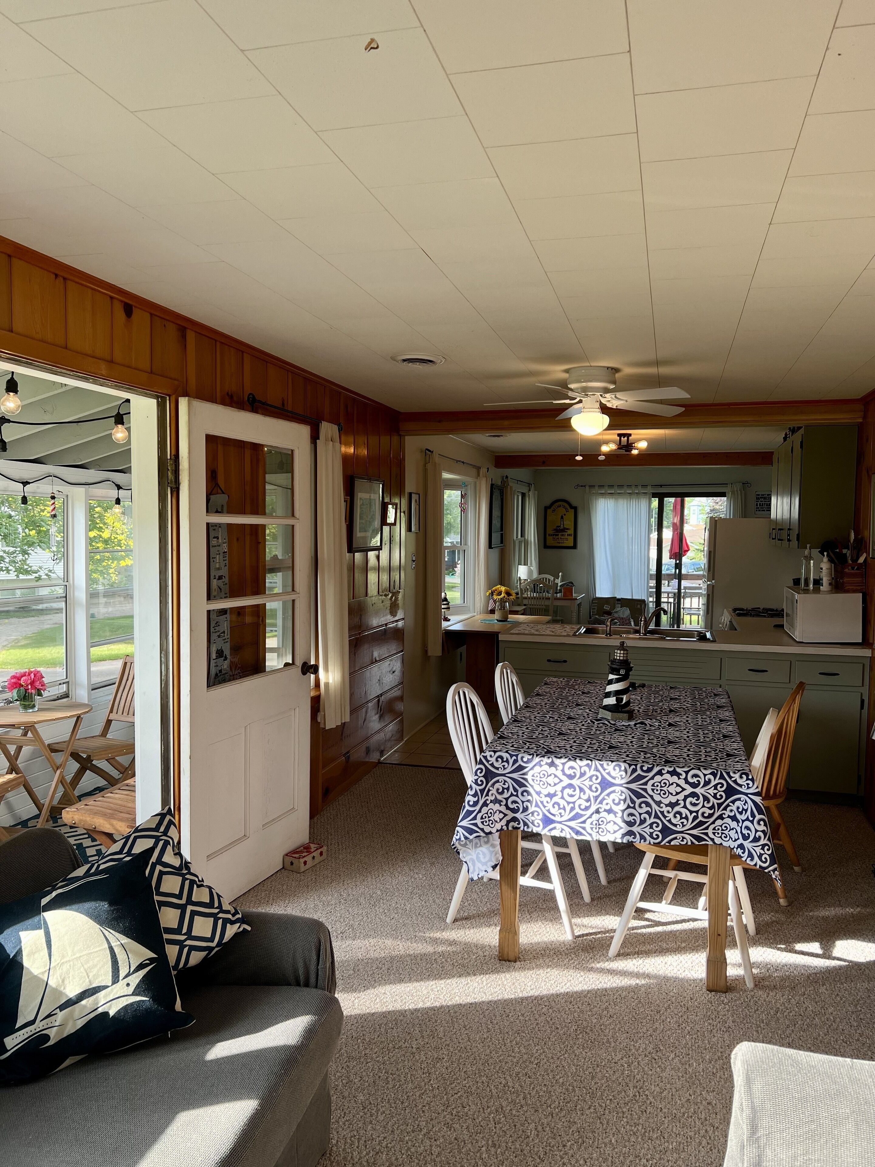 Una habitación acogedora con una mesa de comedor, sillas, un sofá y una zona de cocina.