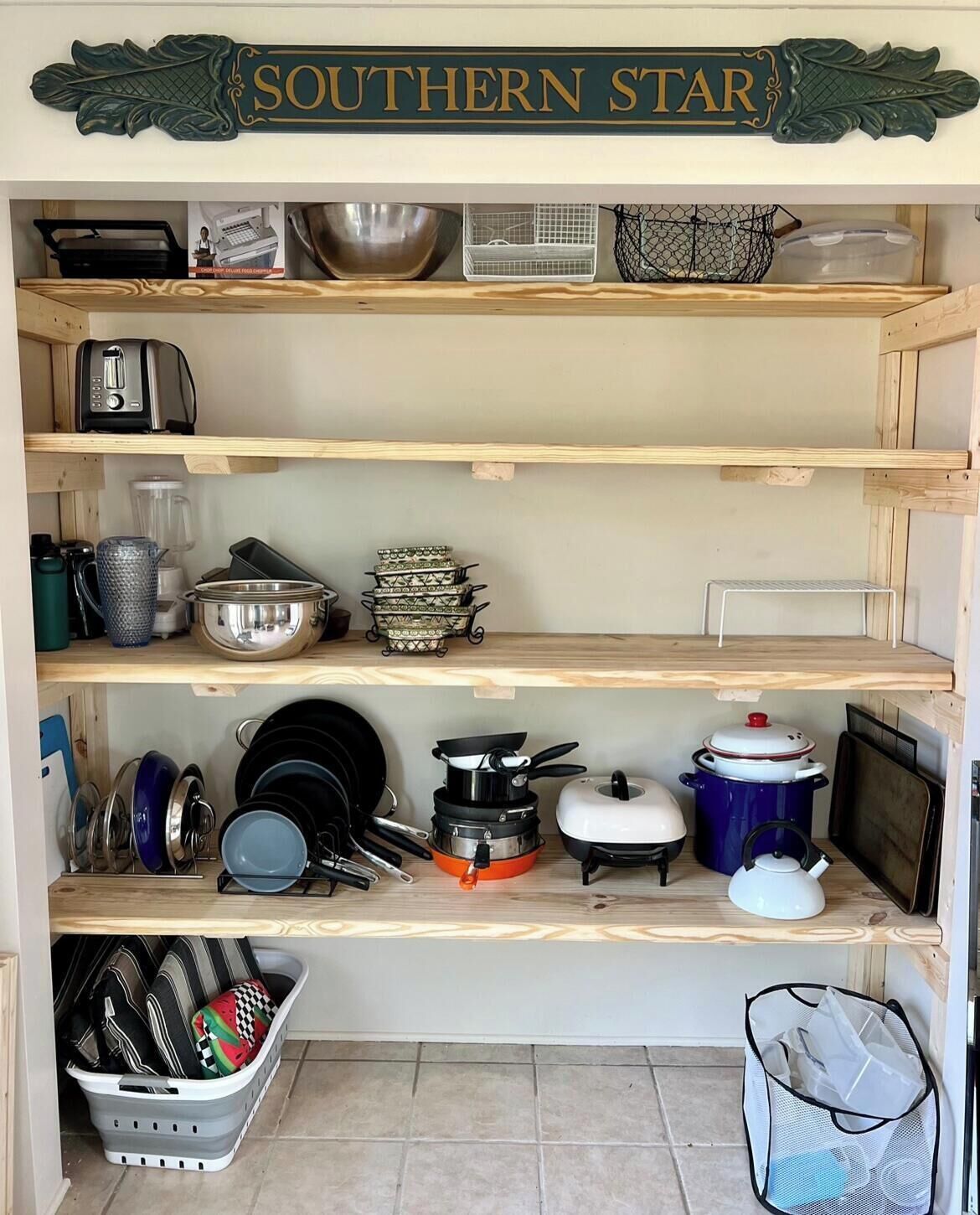 Una cocina con estantes de madera, diverso utensilio de cocina y un letrero que dice "SOUTHERN STAR".