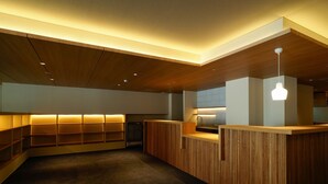 A modern interior with wooden paneling, built-in shelves, and a central counter. - Hotel Sanraku (Yamanouchi)