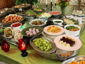 A buffet table with various food items and a decorative candle. - You Resort Hotel (Yamanouchi)