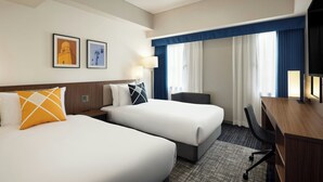 A hotel room with two beds, a desk, and a chair. There are two framed pictures on the wall. - Four Points Flex by Sheraton Yokohama West (Yokohama)