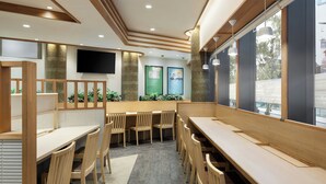 A modern dining area with wooden furniture and a large window. - Four Points Flex by Sheraton Yokohama West (Yokohama)
