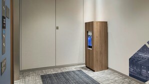 A modern elevator with a digital display, a wooden cabinet, and a patterned carpet in a hallway. - Four Points Flex by Sheraton Yokohama West (Yokohama)