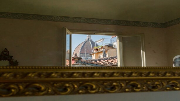 Une pièce d’où l’on peut admirer un bâtiment en forme de dôme à travers une porte ouverte.