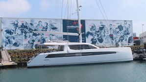 A large yacht docked at a marina with a backdrop of a large poster featuring various individuals. - YOUR HOLIDAY AT  SABLES D'OLONNE THE MOST BEAUTIFUL BEACH ON THE COTE DE LUMIERE (Le Château-d'Olonne)