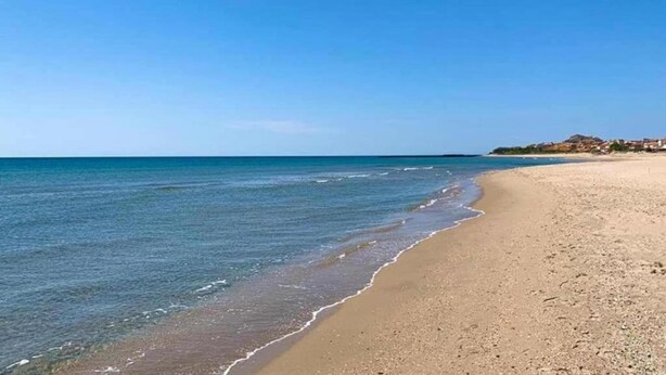 Una spiaggia con acque cristalline e una riva sabbiosa.